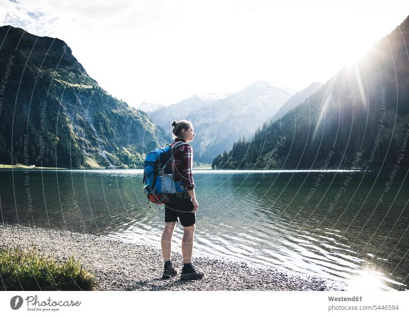 Austria, Tyrol, young woman hiking at mountain lake lakes females women hike mountain lakes mountains water waters body of water Adults grown-ups grownups adult