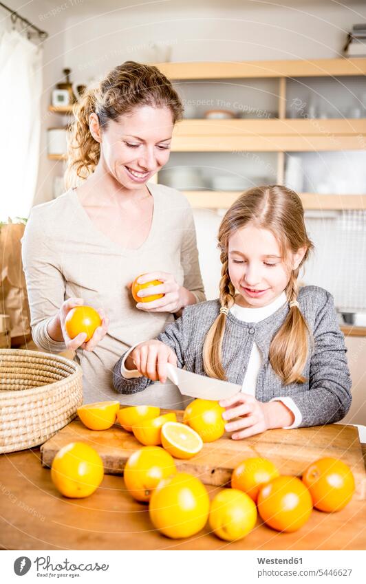 Mother and daughter cutting oranges in kitchen mother mommy mothers ma mummy mama daughters domestic kitchen kitchens Orange Oranges parents family families
