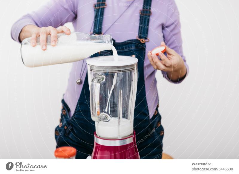 Pregnant woman pouring milk into a blender for preparing smoothie, partial view Smoothies filling in Drink beverages Drinks Beverage food and drink Nutrition