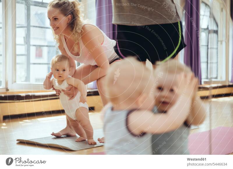 Mothers and babies in exercise room baby infants nurselings smiling smile mirror mirrors Fun having fun funny mother mommy mothers ma mummy mama exercising
