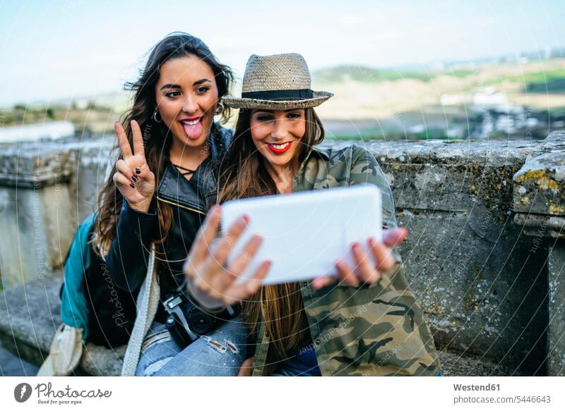 Two happy young women on a trip taking a selfie with a tablet Selfie Selfies female friends smiling smile photographing digitizer Tablet Computer Tablet PC