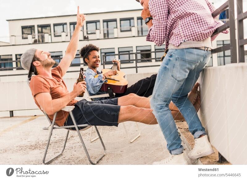 Three friends having a rooftop party Fun having fun funny Party Parties drinking celebrating celebrate partying Beer Beers Ale roof terrace deck guitar guitars
