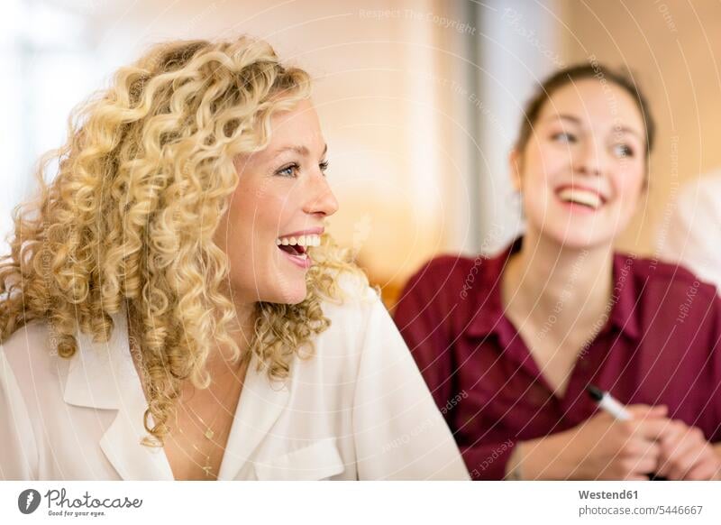 Blond businesswoman listening to presentation females women sitting Seated laughing Laughter blond blond hair blonde hair workshop Adults grown-ups grownups