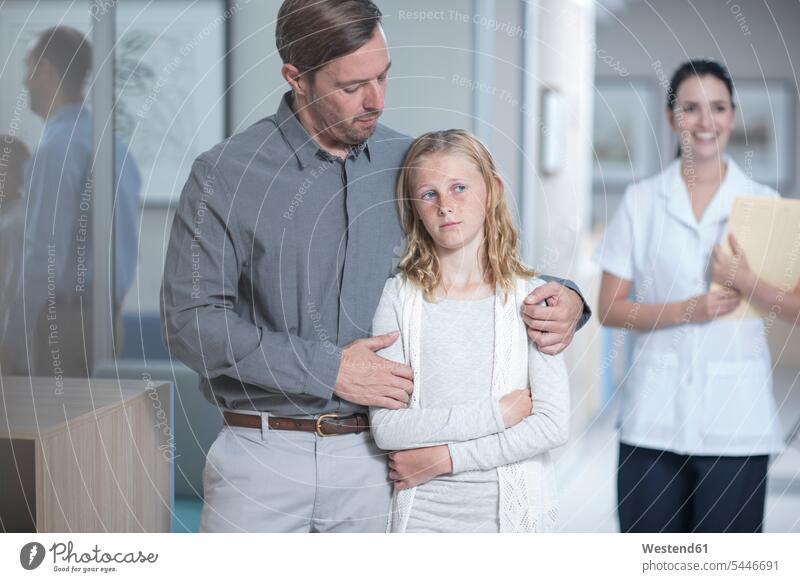 Father guiding sick daughter in hospital patient father fathers daddy dads papa nurse nurses ill daughters Medical Clinic doctor physicians doctors clinic