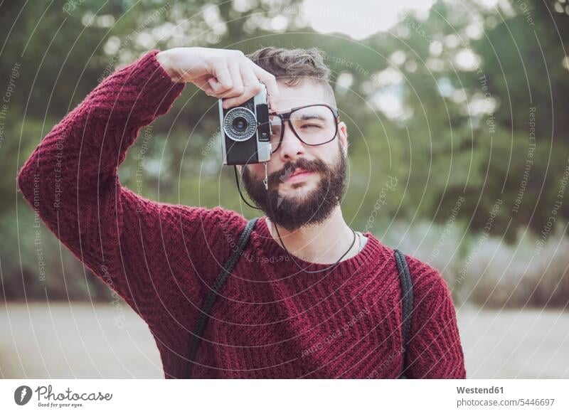 Portrait of bearded man with glasses taking photo with vintage camera portrait portraits men males photographing Adults grown-ups grownups adult people persons