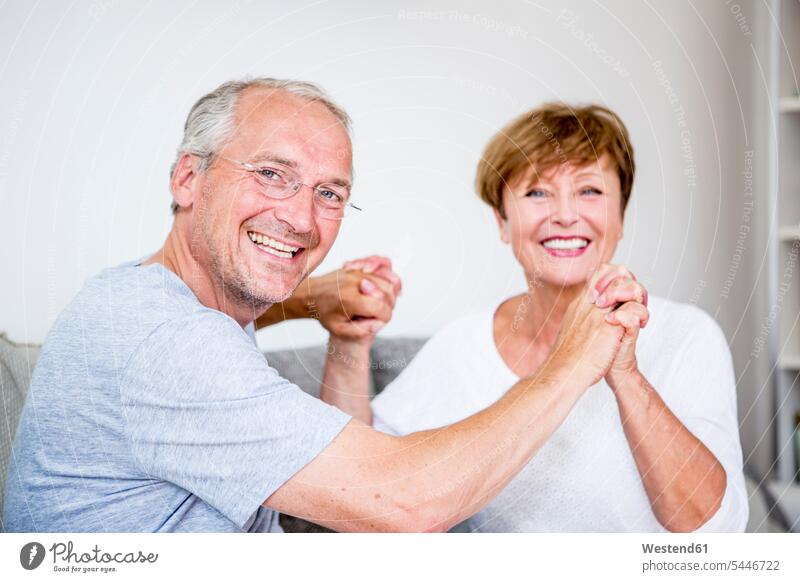 Portrait of happy senior couple at home couch settee sofa sofas couches settees twosomes partnership couples relaxed relaxation people persons human being