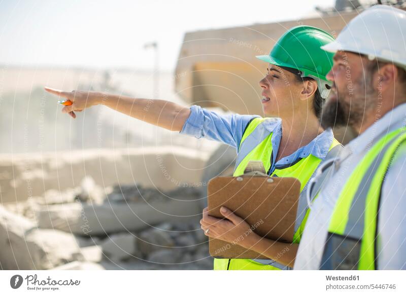 Male and female quarry workers discussing on site gravel pit blue collar worker blue-collar worker mining checking Test testing Check working At Work colleagues