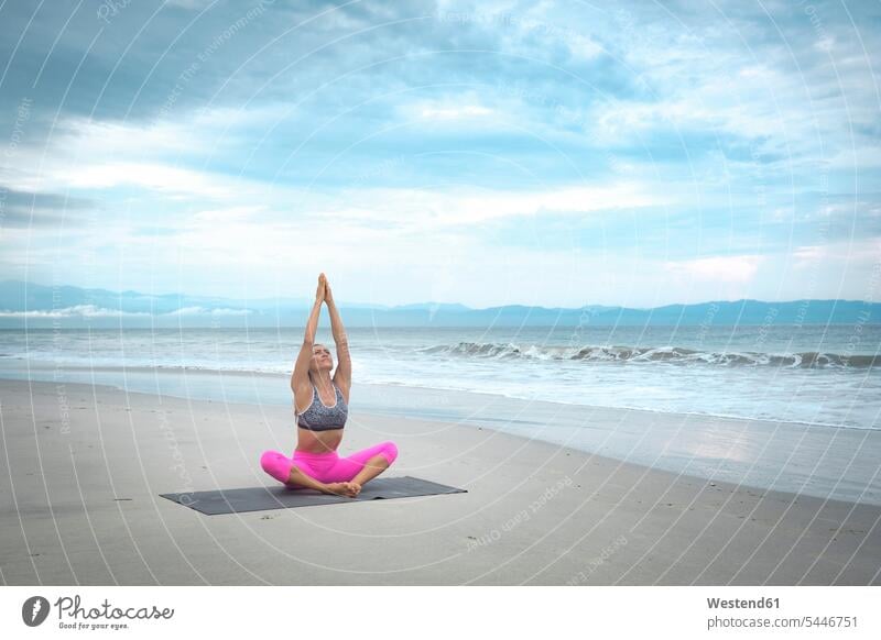 Woman practicing yoga on the beach beaches woman females women sportive sporting sporty athletic fit practice practise exercise exercising practising Adults