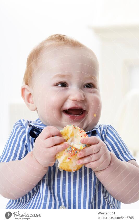 Portrait of happy baby boy with muffin laughing Laughter eating infants nurselings babies portrait portraits positive Emotion Feeling Feelings Sentiments