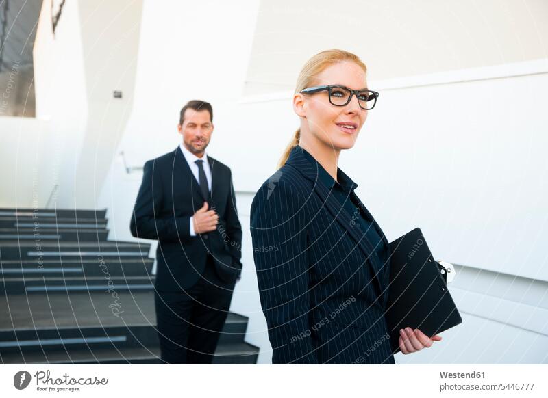 Confident businesswoman and businessman outside office building business world business life businesswomen business woman business women Businessman