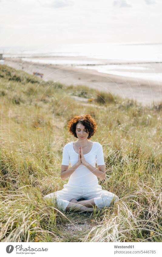 Woman practicing yoga in beach dune sand dune sand dunes beaches woman females women mindfulness aware awareness self-care relaxation exercise relaxed relaxing