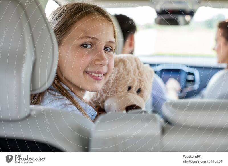 Happy family doing a road trip, daughter looking at camera father pa fathers daddy dads papa driving drive car automobile Auto cars motorcars Automobiles
