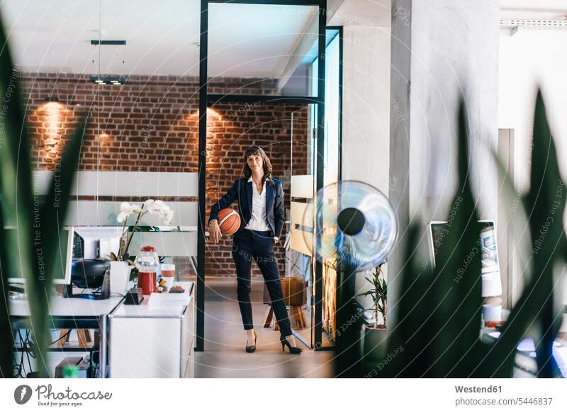 Businesswoman holding basket ball in office balls skill Ability skilled fairness basketball basketballs sportive sporting sporty athletic Office Offices