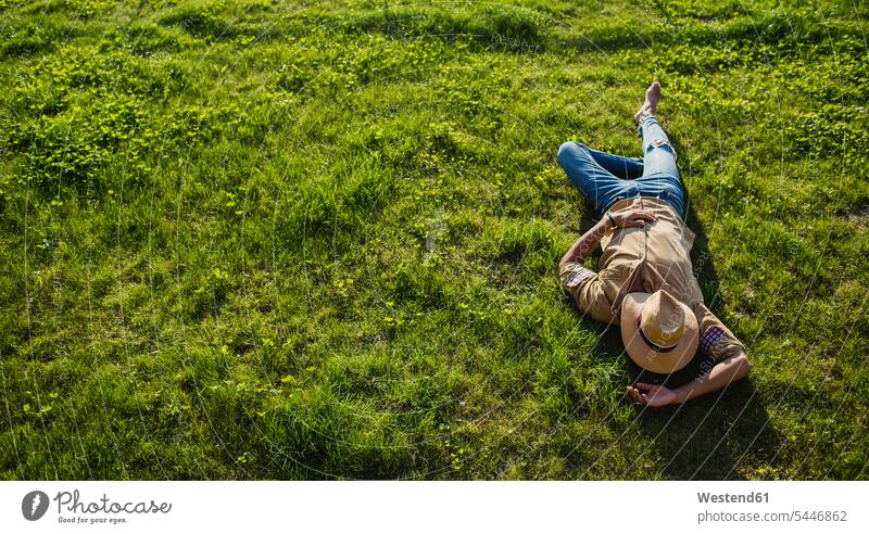Young man sleeping on a meadow, top view men males lying laying down lie lying down meadows Adults grown-ups grownups adult people persons human being humans