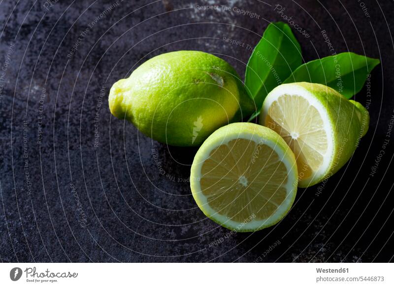 Green organic lemons on dark background copy space elevated view High Angle View High Angle Shot healthy eating nutrition half halves halved sliced juicy