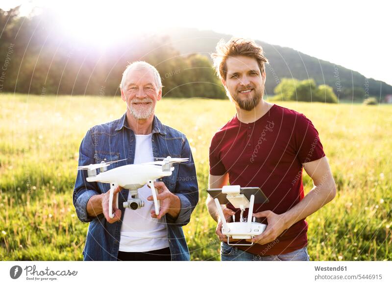 Portrait of senior father and his adult son with drone on a meadow portrait portraits adult sons drones pa fathers daddy dads papa adult child adult children