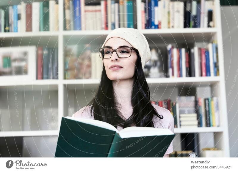 Young woman holding book looking sideways females women books reading portrait portraits Adults grown-ups grownups adult people persons human being humans