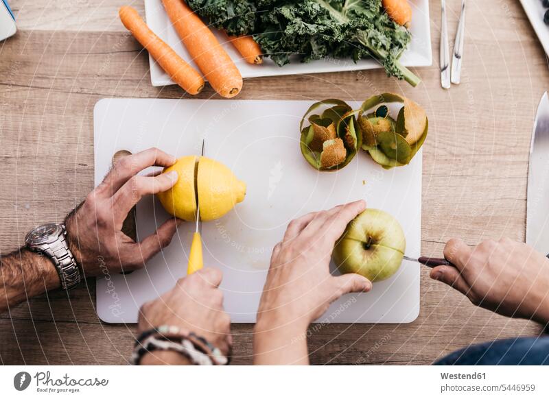 Hands of couple cutting fruits for preparing smoothies hand human hand hands human hands people persons human being humans human beings kitchen domestic kitchen