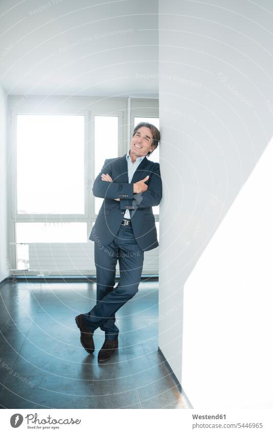 Portrait of smiling businessman standing on office floor smile portrait portraits offices office room office rooms Businessman Business man Businessmen