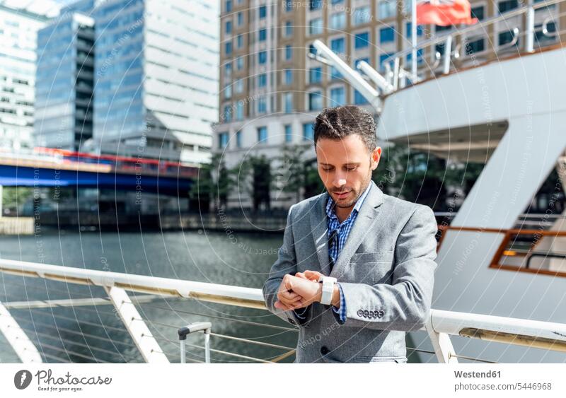 Businessman checking the time in the city wrist watch Wristwatch Wristwatches wrist watches Business man Businessmen Business men business people businesspeople