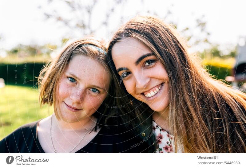 Portrait of two smiling girls outdoors sister sisters females portrait portraits happiness happy smile siblings brother and sister brothers and sisters family