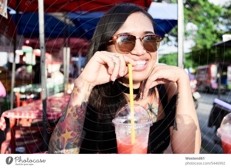 Portrait of happy woman drinking a smoothie outdoors Smoothies happiness females women Drink beverages Drinks Beverage food and drink Nutrition Alimentation