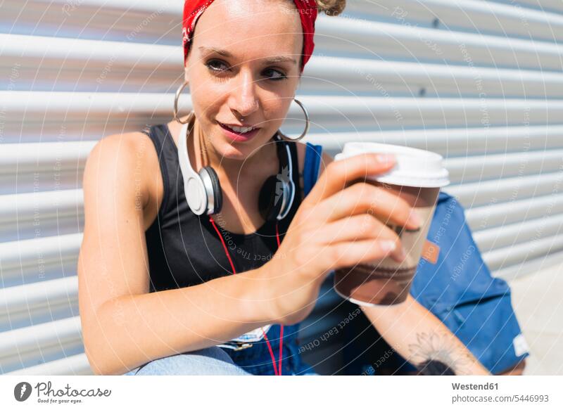 Portrait of young woman with headphones and coffee to go portrait portraits females women Adults grown-ups grownups adult people persons human being humans