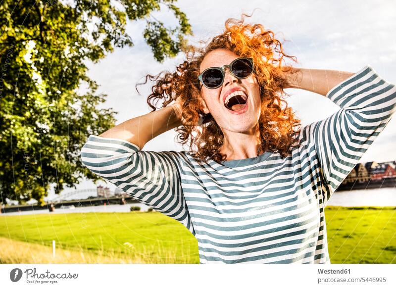Germany, Cologne, portrait of screaming redheaded young woman wearing sunglasses females women laughing Laughter portraits Adults grown-ups grownups adult