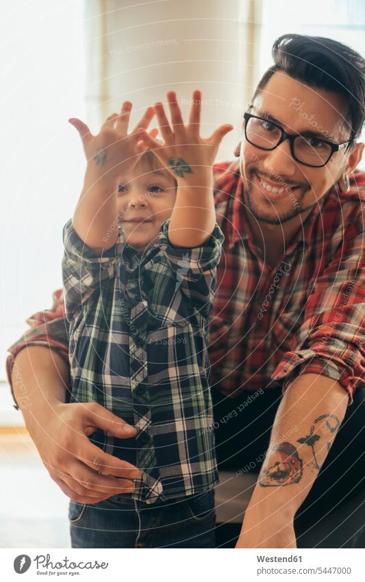 Proud son showing painted tattoos on his hands sons manchild manchildren father fathers daddy dads papa smiling smile family families people persons human being
