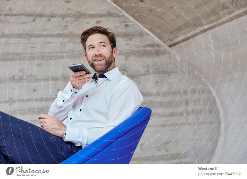 Businessman sitting on chair using cell phone Business man Businessmen Business men on the phone call telephoning On The Telephone calling mobile phone mobiles
