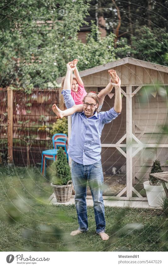 Father carrying daughter in garden father pa fathers daddy dads papa smiling smile playing daughters gardens domestic garden parents family families people