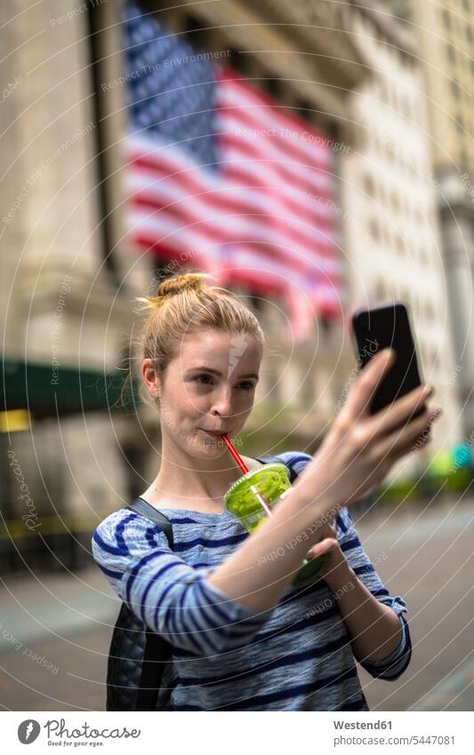 USA, New York City, woman taking selfie in front of New York Stock Exchange Selfie Selfies females women mobile phone mobiles mobile phones Cellphone cell phone