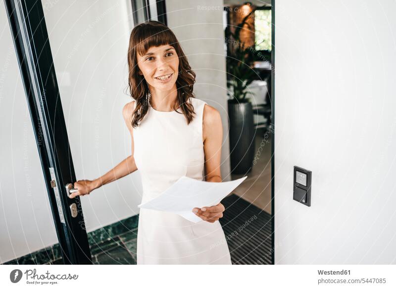 Businesswoman entering office, holding documents smiling smile working At Work office worker door doors opening white collar worker clerk office occupation