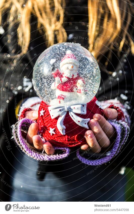 Girl's hands holding snow globe with snowman, close up snowmen girl females girls human hand human hands snow globes child children kid kids people persons