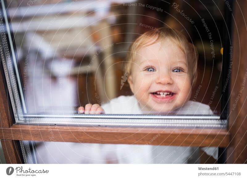 Laughing baby boy looking out of window windows laughing Laughter baby boys male babies infants positive Emotion Feeling Feelings Sentiments Emotions emotional