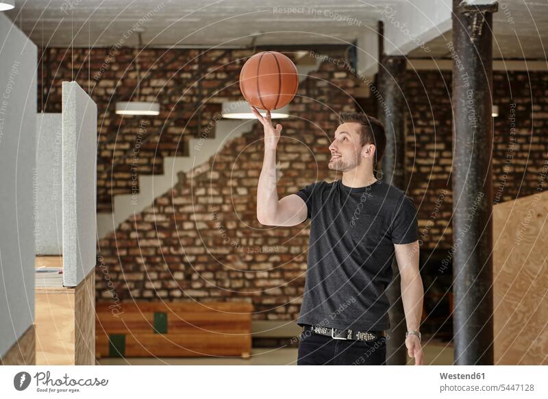 Young man in office playing with basketball skill Ability skilled smiling smile work-life balance Work Life Balance balls Basketball offices office room