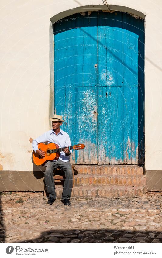 Cuba, man playing guitar on the street guitarist guitarists men male adults males street musician street musicians Adults grown-ups grownups people persons