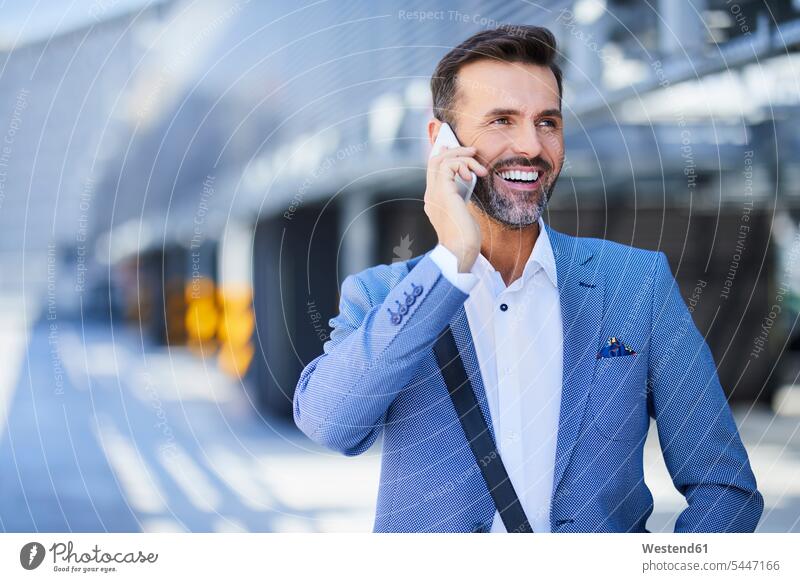 Businessman talking on the phone in the city smiling smile call telephoning On The Telephone calling Business man Businessmen Business men mobile phone mobiles