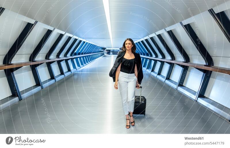 Businesswoman with suitcase walking through a tunnel going suitcases businesswoman businesswomen business woman business women business people businesspeople
