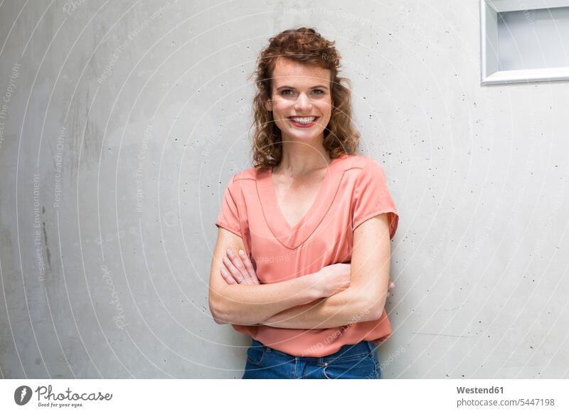 Portrait of smiling woman leaning against concrete wall smile concrete walls females women Adults grown-ups grownups adult people persons human being humans