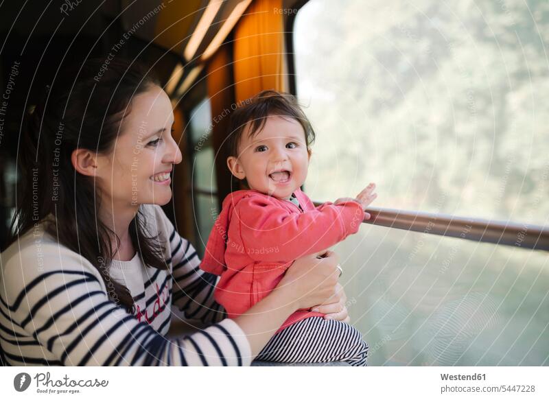 Happy mother and baby girl traveling by train laughing Laughter infants nurselings babies travelling mommy mothers ma mummy mama positive Emotion Feeling