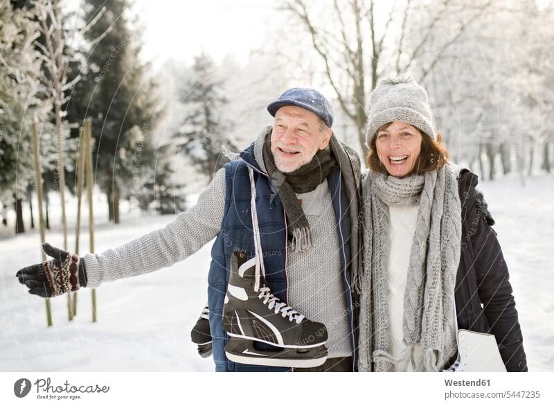 Happy senior couple with ice skates in winter landscape twosomes partnership couples ice skater skaters ice skaters Fun having fun funny forest woods forests