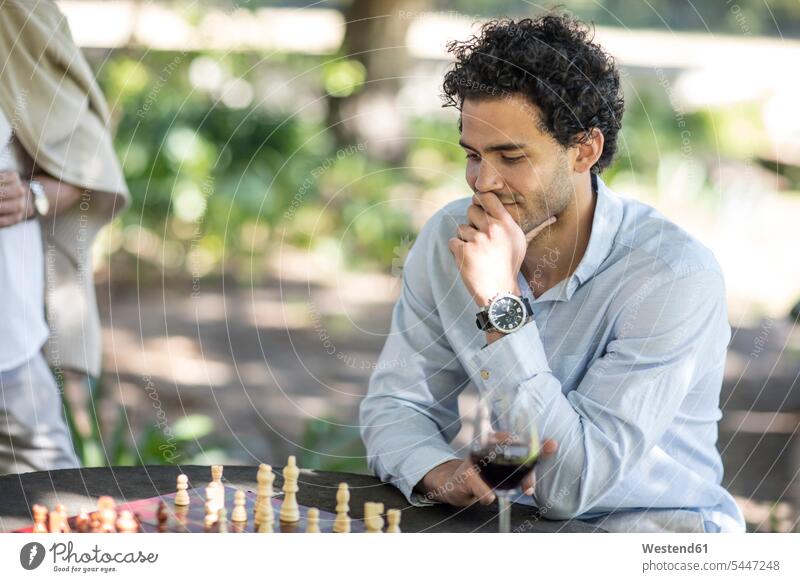 Man playing game of chess thinking man men males cogitate Adults grown-ups grownups adult people persons human being humans human beings board game board-games