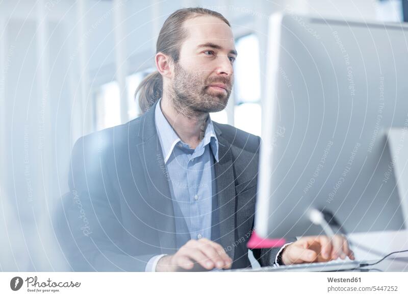 Businessman in office working on a computer computers offices office room office rooms Business man Businessmen Business men At Work workplace work place