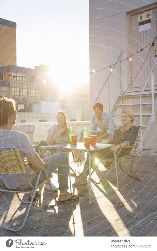 Friends having a rooftop party on a beautiful summer evening roof terrace deck friends together enjoying indulgence enjoyment savoring indulging summer time