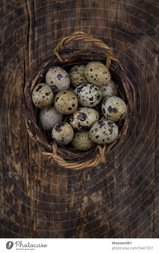 Wickerbasket of quail eggs on dark wood studio shot studio shots studio photograph studio photographs still life still-lifes still lifes brown rustic dotted