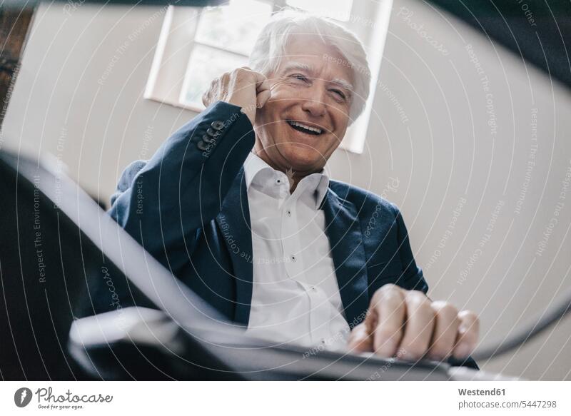 Portrait of laughing senior businessman on the phone in his office Businessman Business man Businessmen Business men offices office room office rooms call