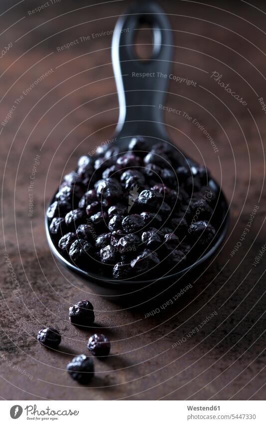 Spoon of dried chokeberries on rusty metal black many plenty dried fruit Dried Fruits dark background superfood spoon spoons chokeberry Aronia healthy eating