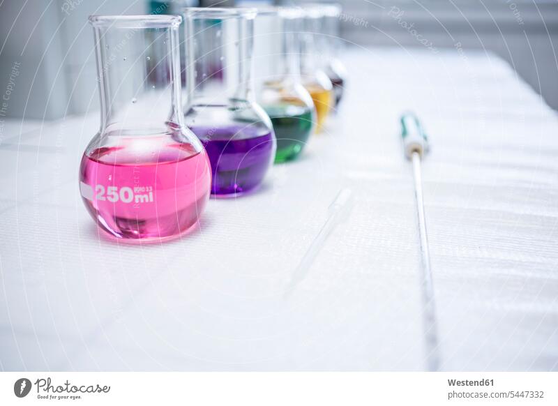 Multicolored liquids in flasks in lab recipient Chemical Flasks science sciences scientific laboratory workplace work place place of work copy space equipment
