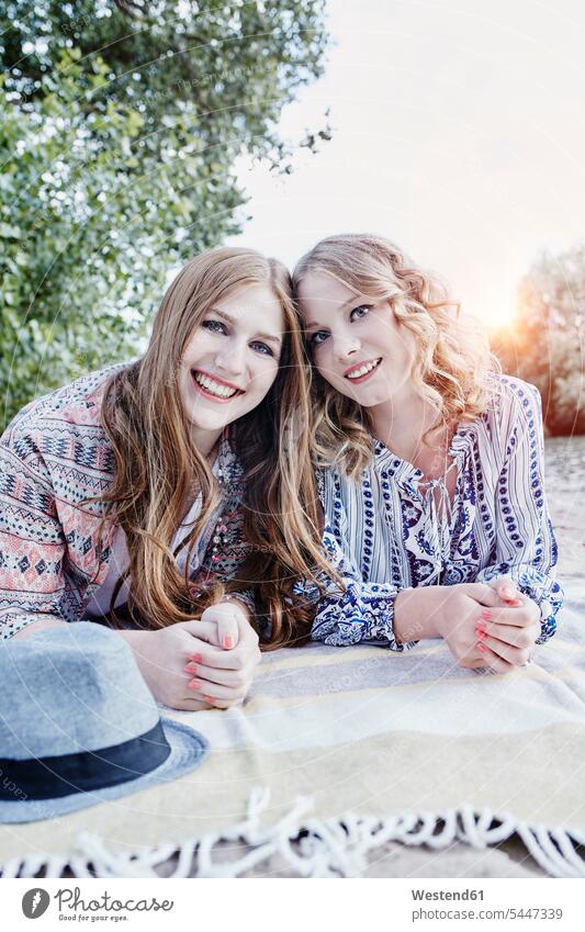 Portrait of two teenage girls relaxing on blanket on the beach portrait portraits beaches female friends mate friendship Teenage Girls female teenagers smiling